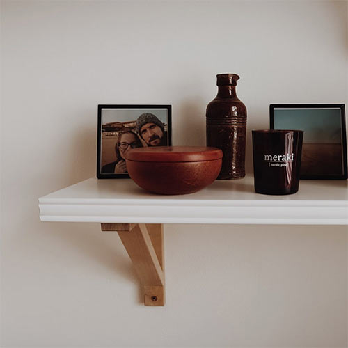 minimalistic decor - a shelf with two photos and some homewares