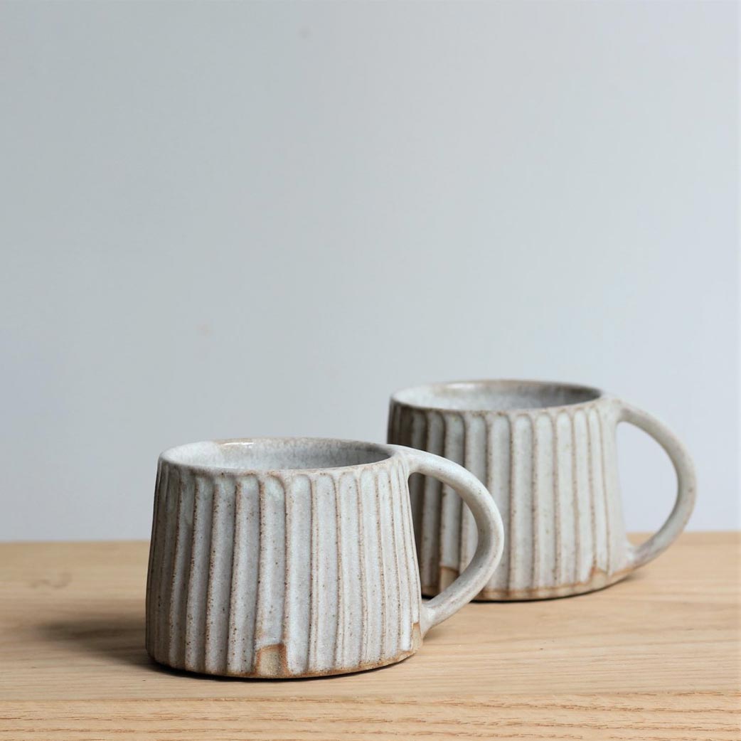 two carved mugs on a table