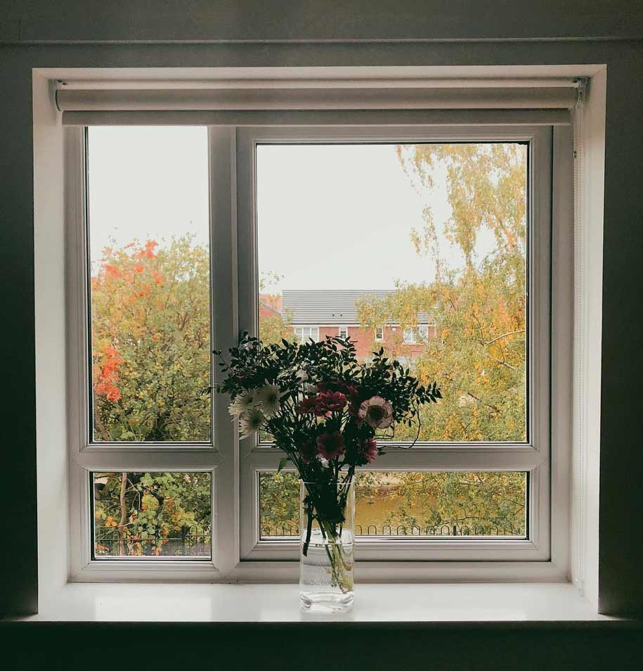 a vase with flowers on a windowsill in jen carrington's home