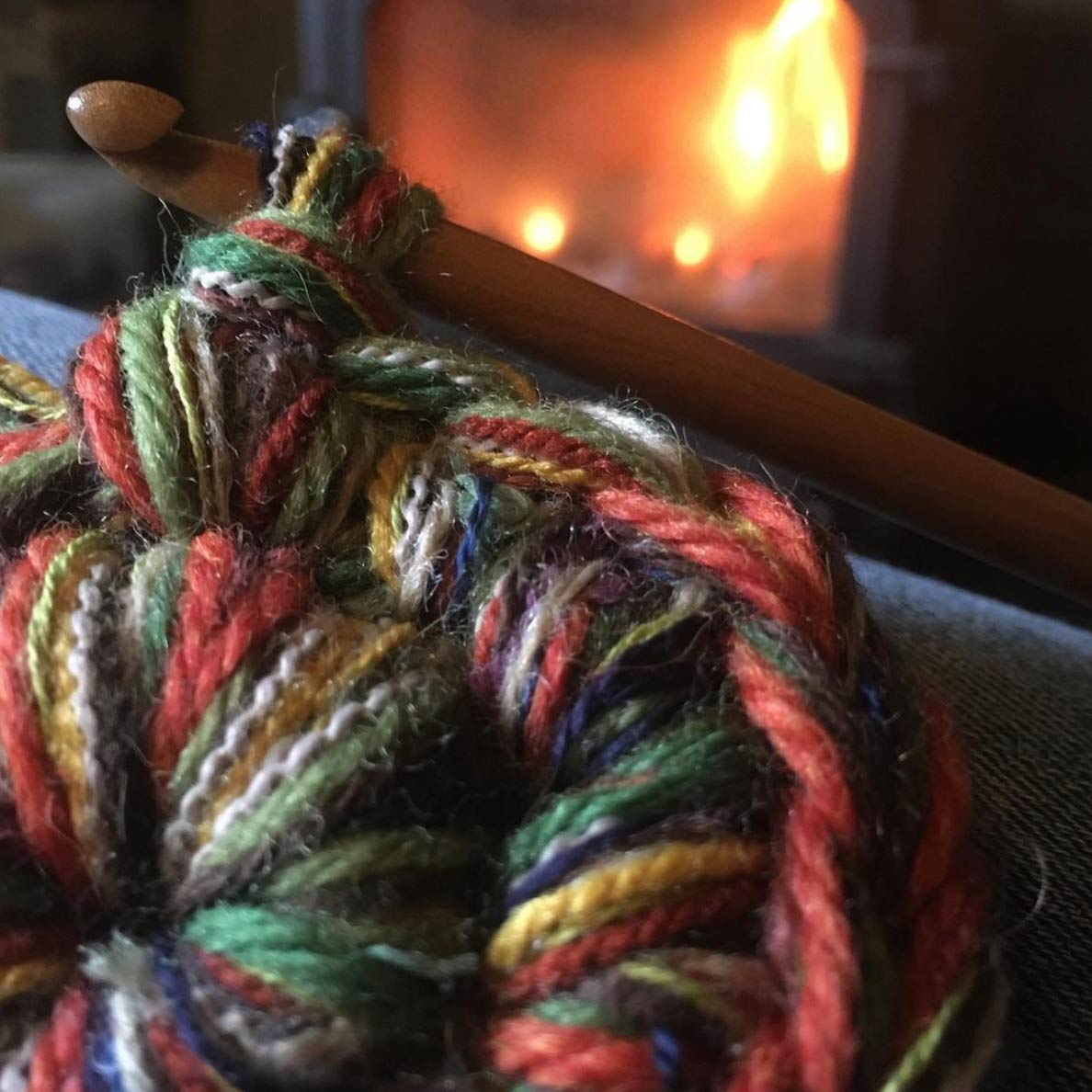 pothies crocheting slippers  in front of a fireplace