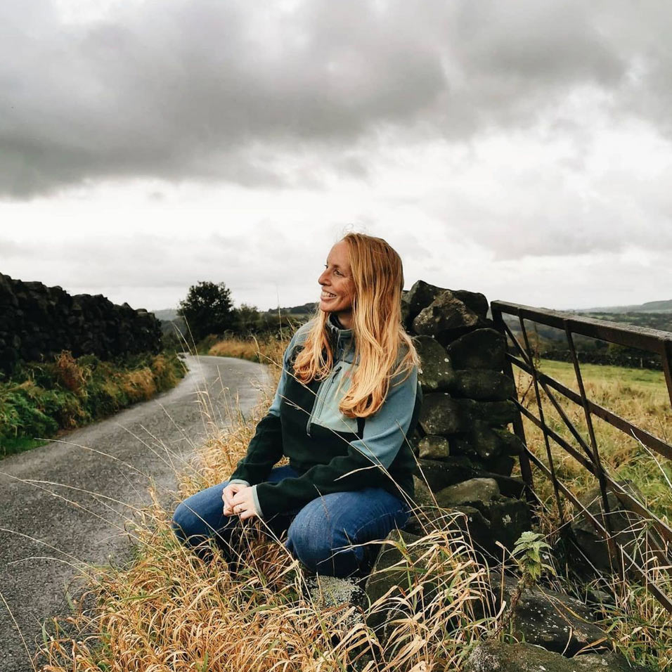 ruth allen kneeling by a gravel road in the countryside