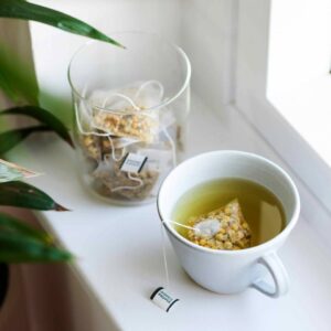 a cup of tea and a jar of tea bags from Good & Proper Tea