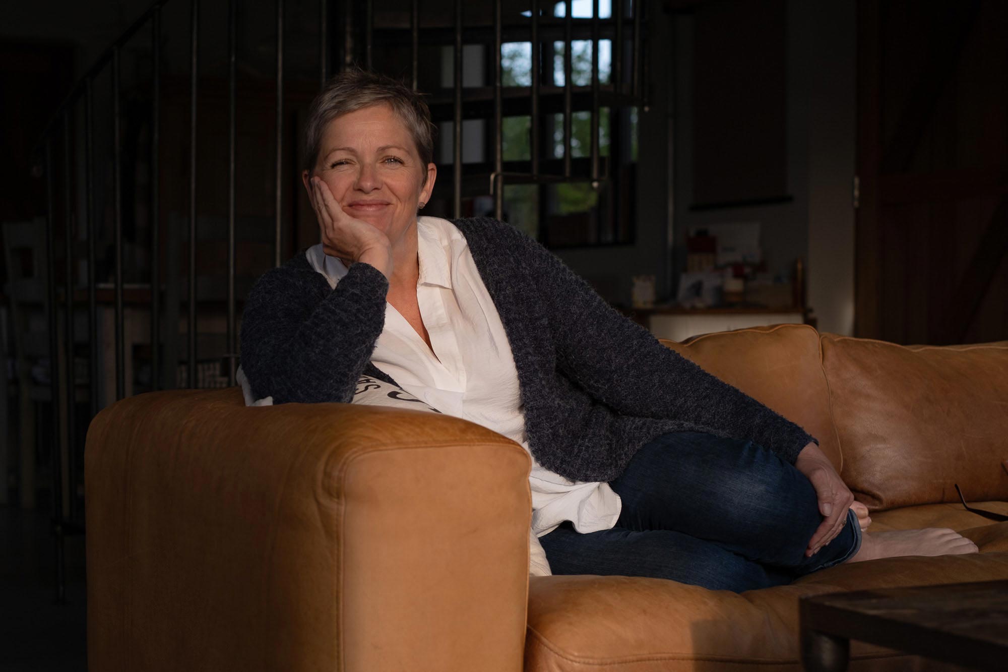 a woman on a bed with a laptop, holding a cup of coffee - next steps to future-proof your small business