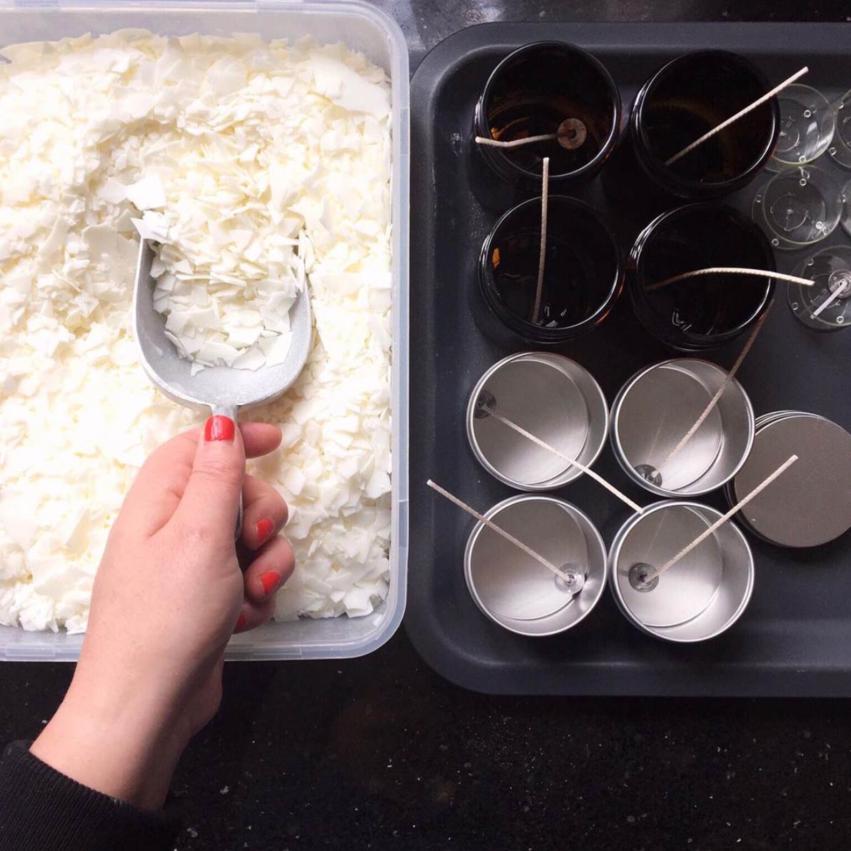 a woman's hand scooping soy flakes to melt