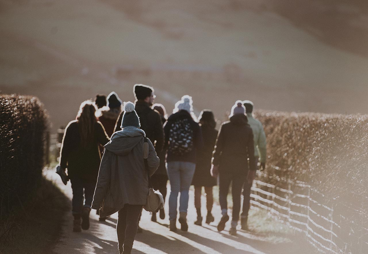 a group of people walking in the countryside - experiences