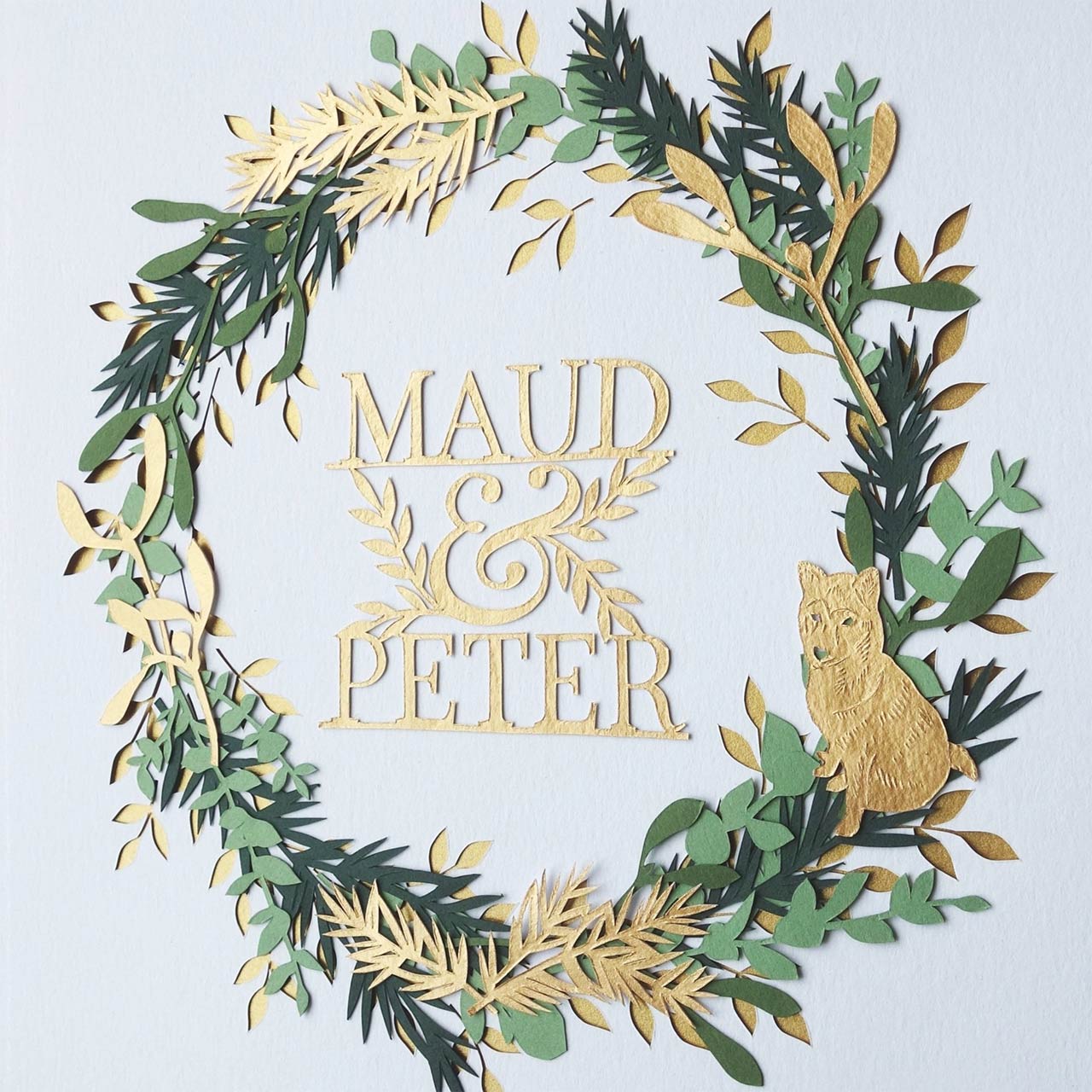 paper cut art work with green leaves in a circle with the names Maud & Peter in gold in the middle