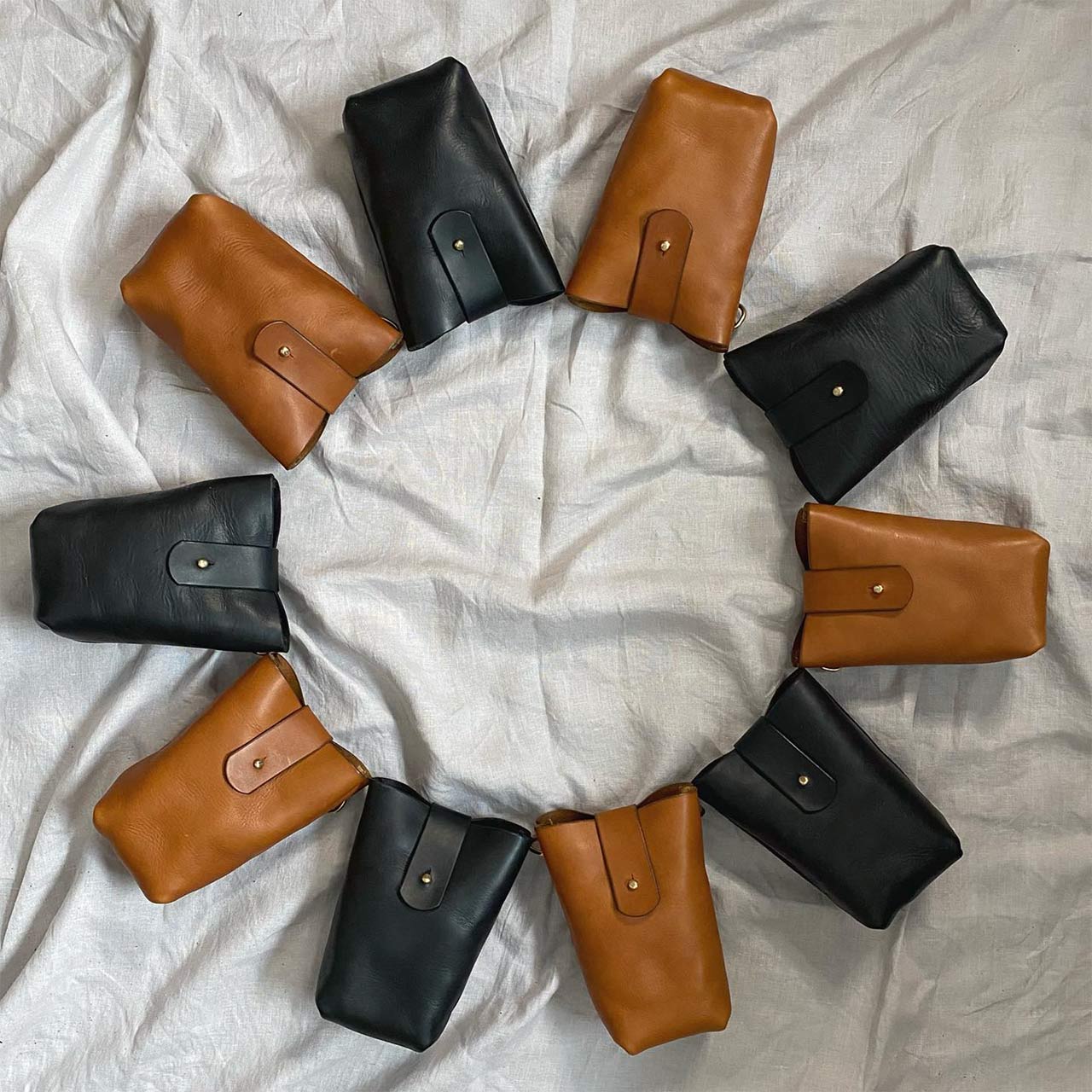 flatlay of brown and black leather bags laid out in a circle