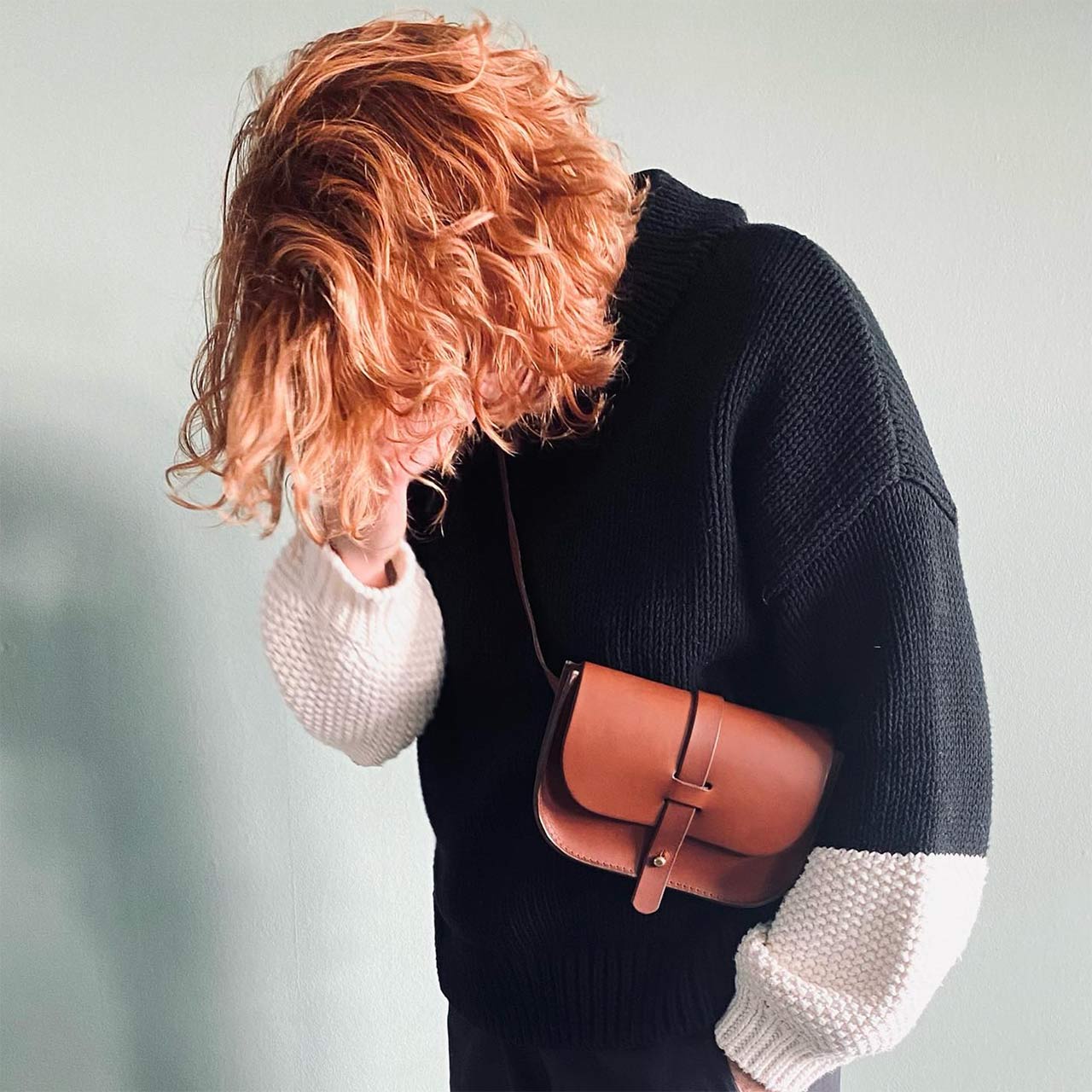 red haired woman with a black sweater wearing a brown leather belt bag from p kirkwood leather works