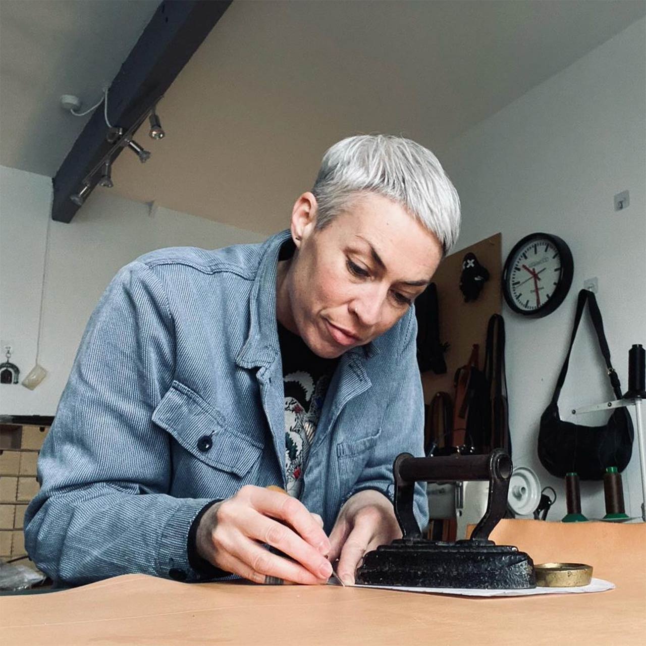 Paula Kirkwood cutting leather at a table