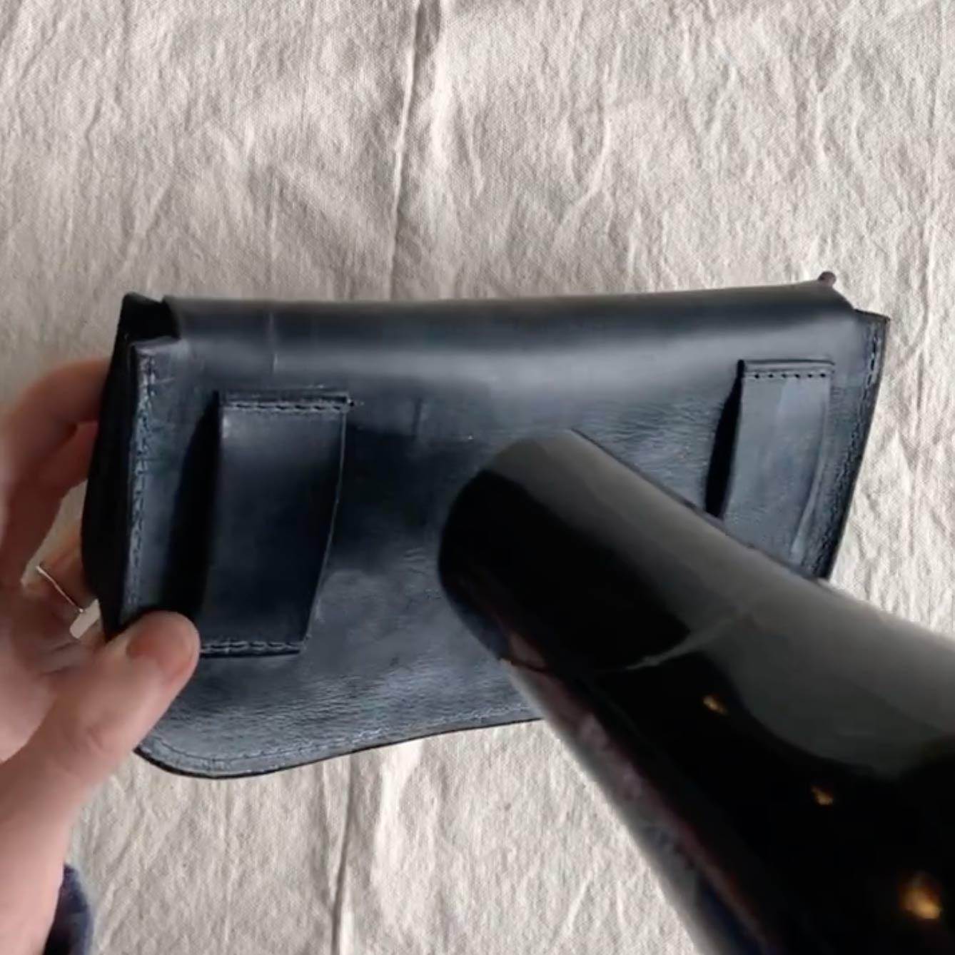 blowing hot air with a hairdryer onto a bag to melt the solidified wax