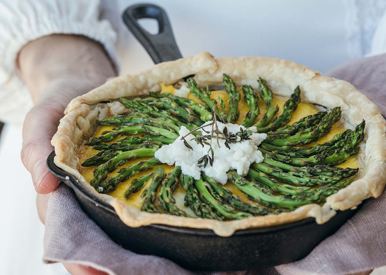 slow living in spring - person holding an asparagus pie
