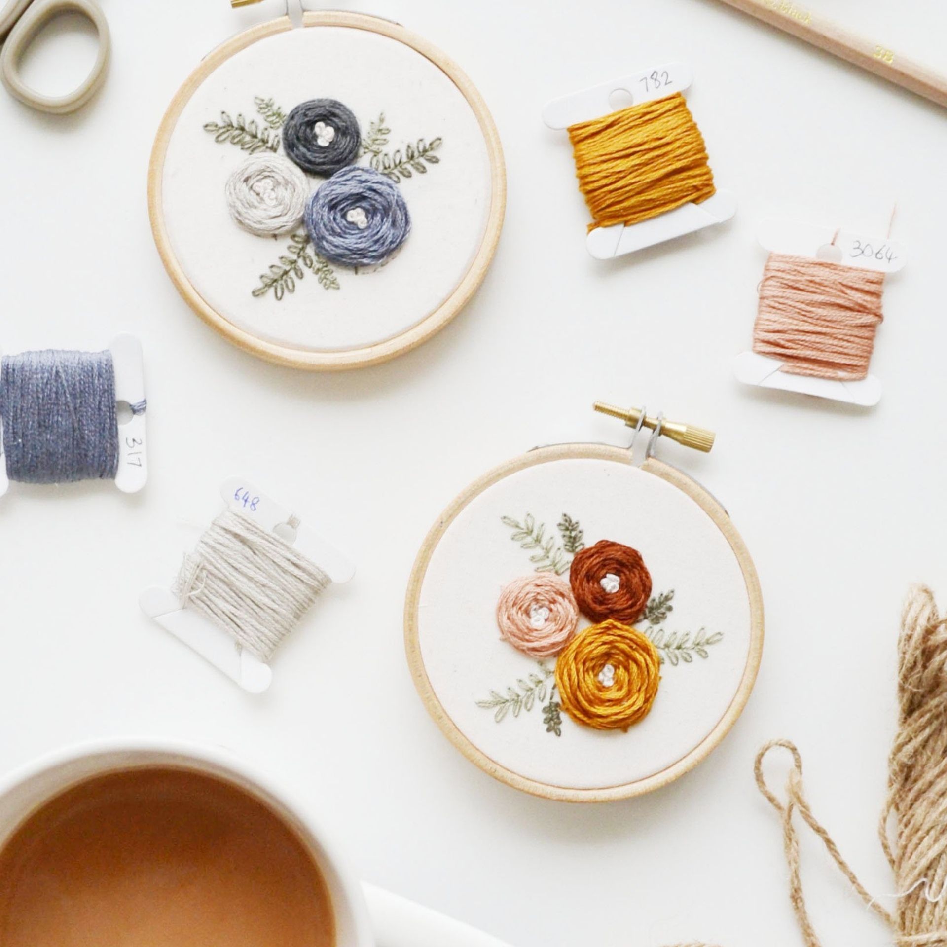 two floral embroideries in hoops from the artist's lab