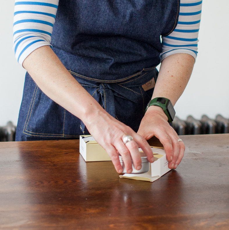 close up of a woman's hand packing soap - simple home holism