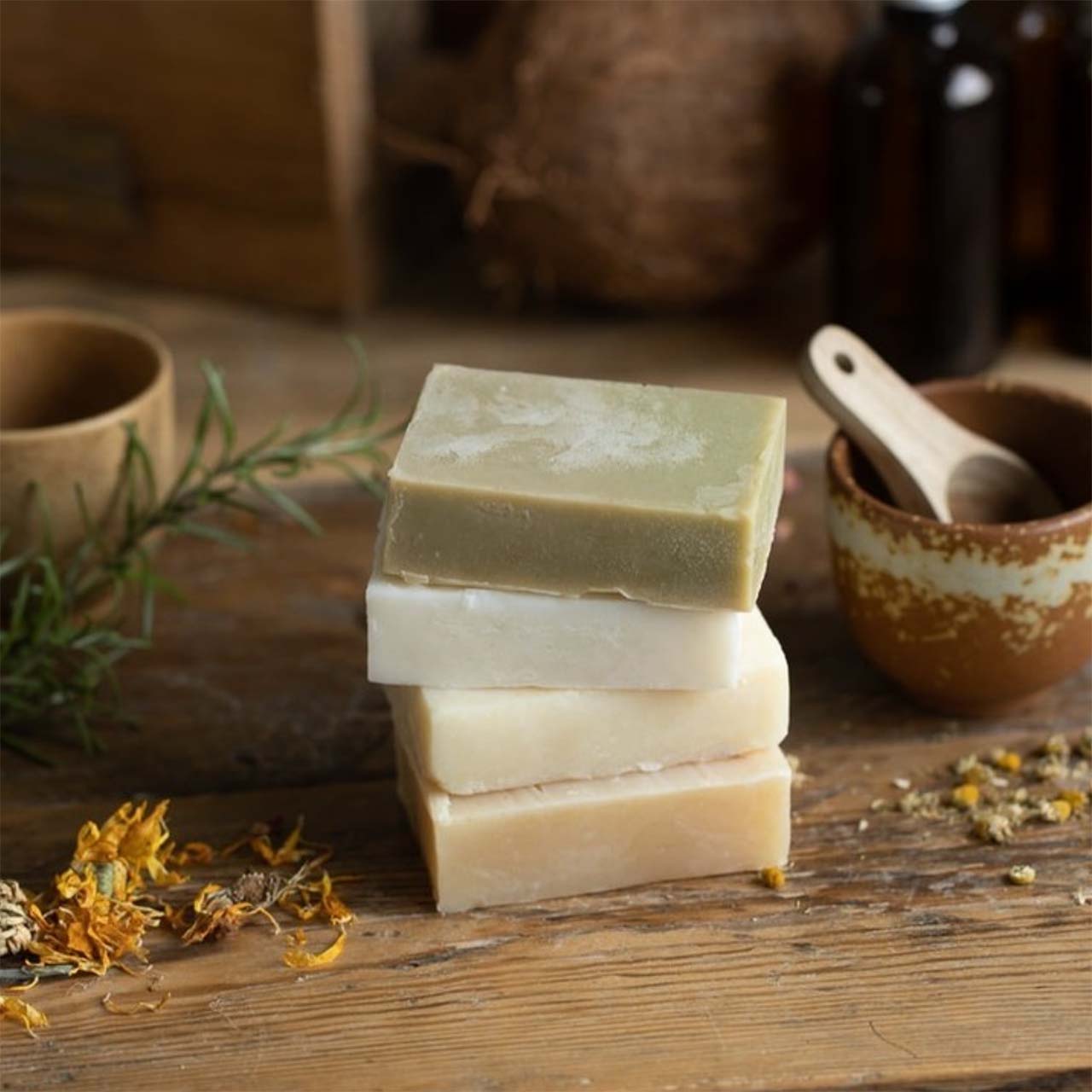 a stack of handmade soap bars by simple home holism on a wooden table