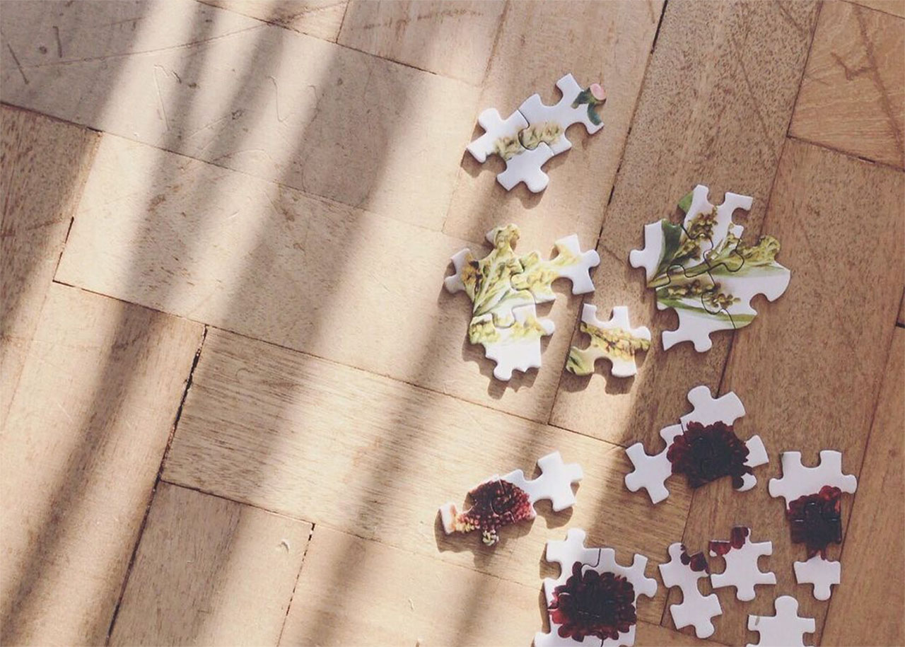 pieces of a puzzle on a wooden floor - balance between work and play
