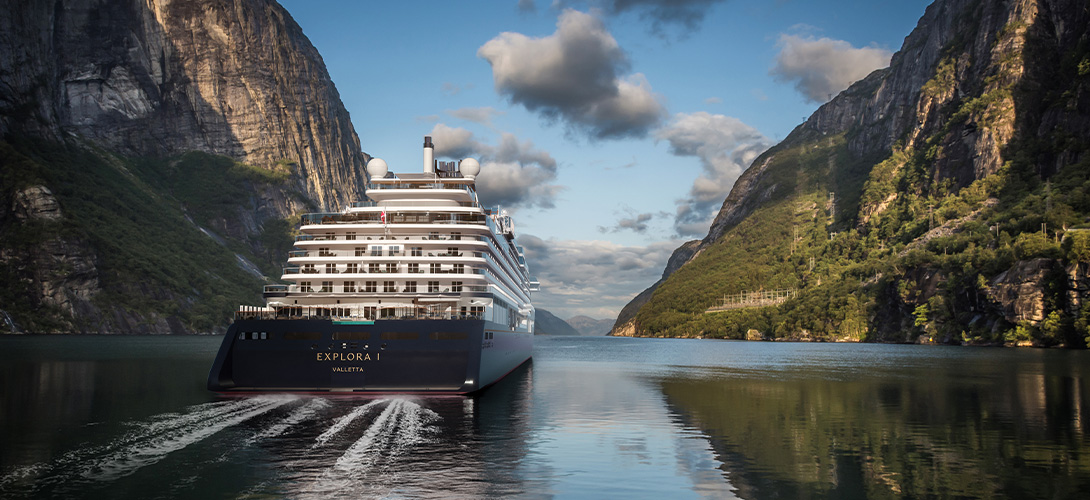 cruise ship seen from behind with mountains sailing through fjords - why slow travel is the perfect way to enjoy summer