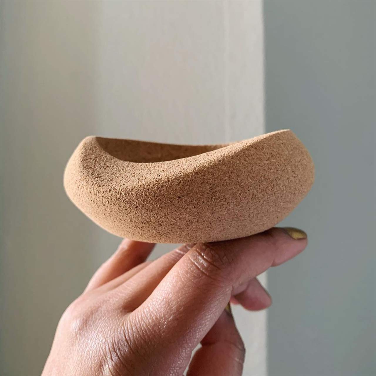 a hand holding a cork basket