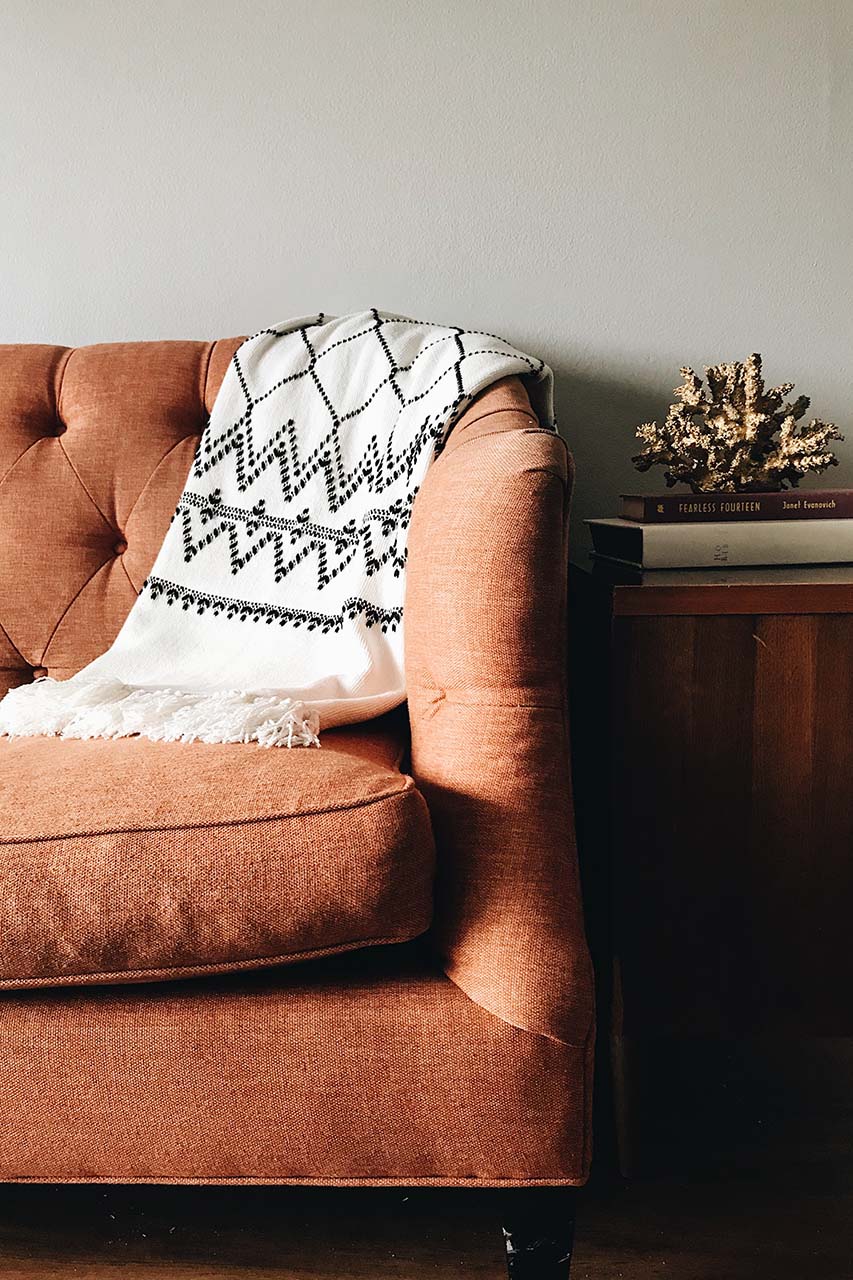 a cosy blanket draped on a couch