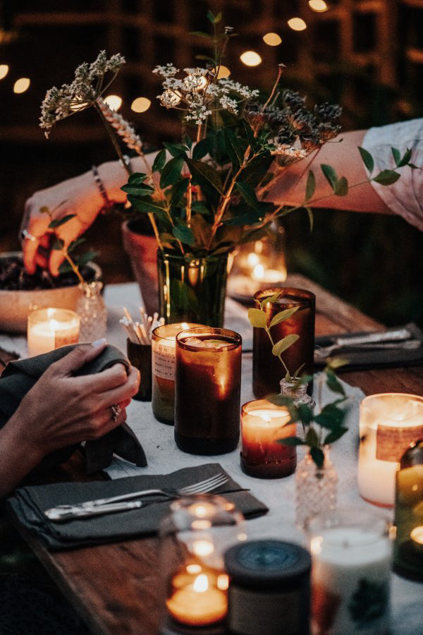 people sitting at a beautifully decorated table with candles glowing