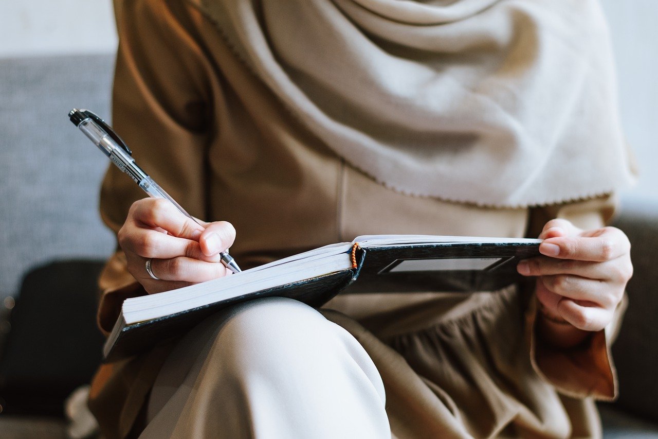 a woman on a bed with a laptop, holding a cup of coffee - next steps to future-proof your small business