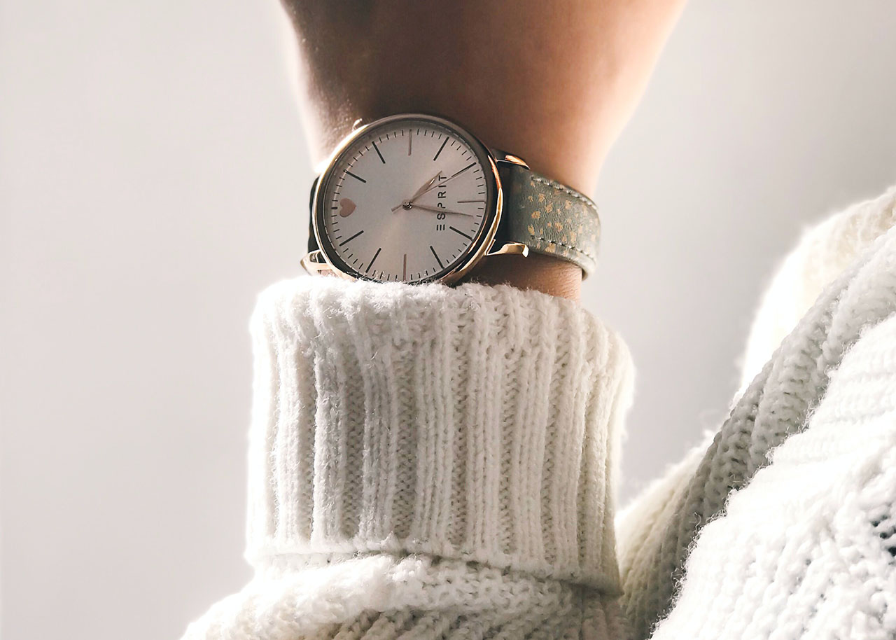 a woman's wrist showing her wool sweater and a stylish watch