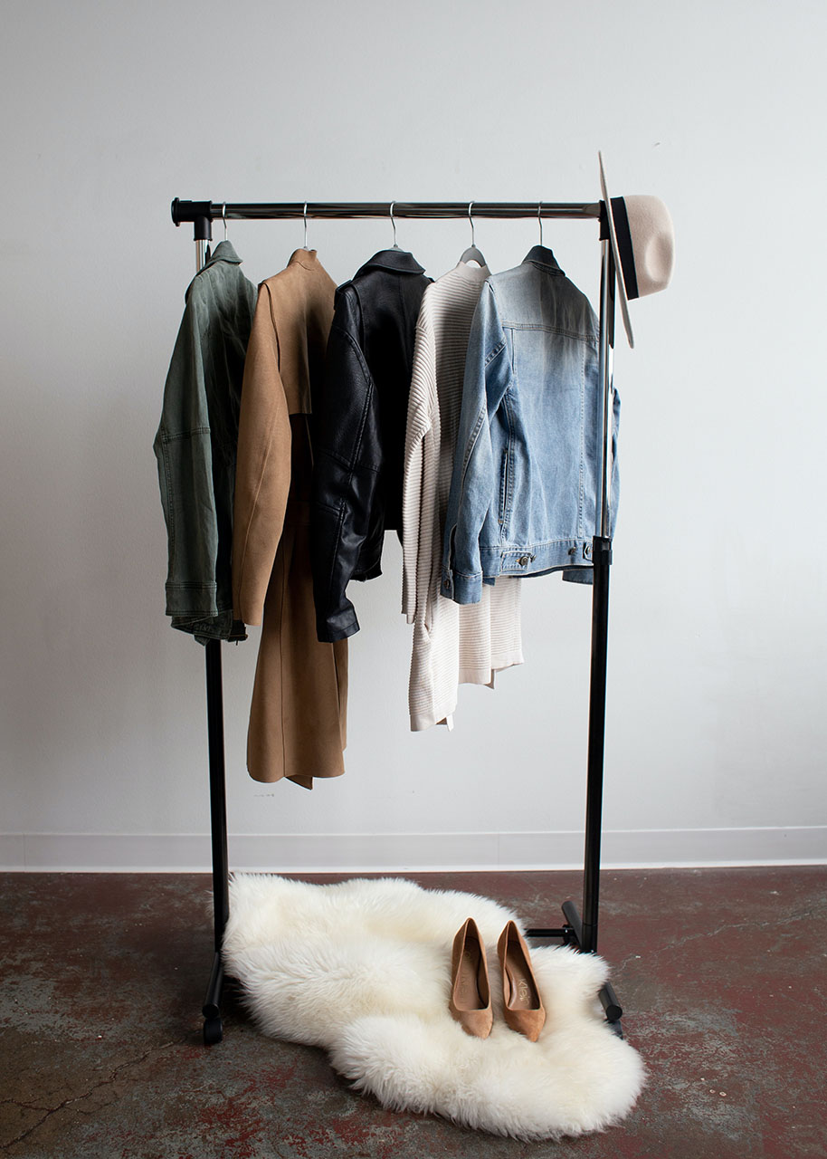 capsule wardrobe of investment pieces - a rack with five pieces of clothing, a pair of high heeled shoes and a hat