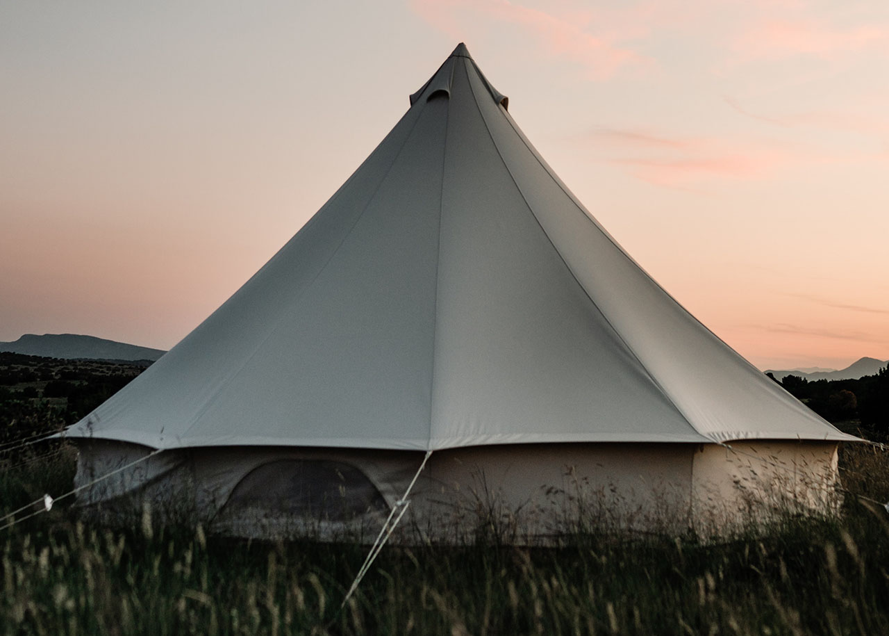 A yurt at sunset with hills in the background - best accommodations for slow travel