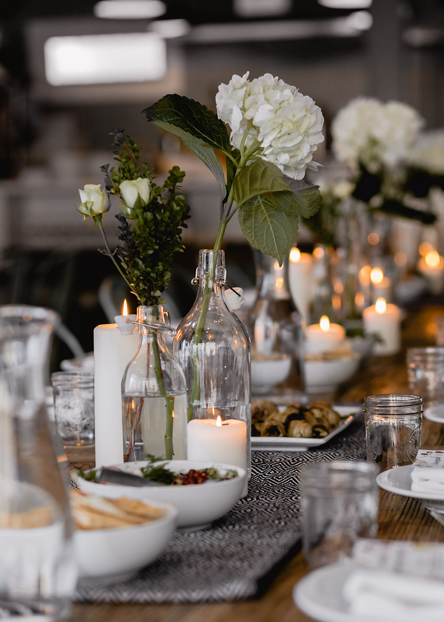 a beautifully set table with candles and vases with flowers