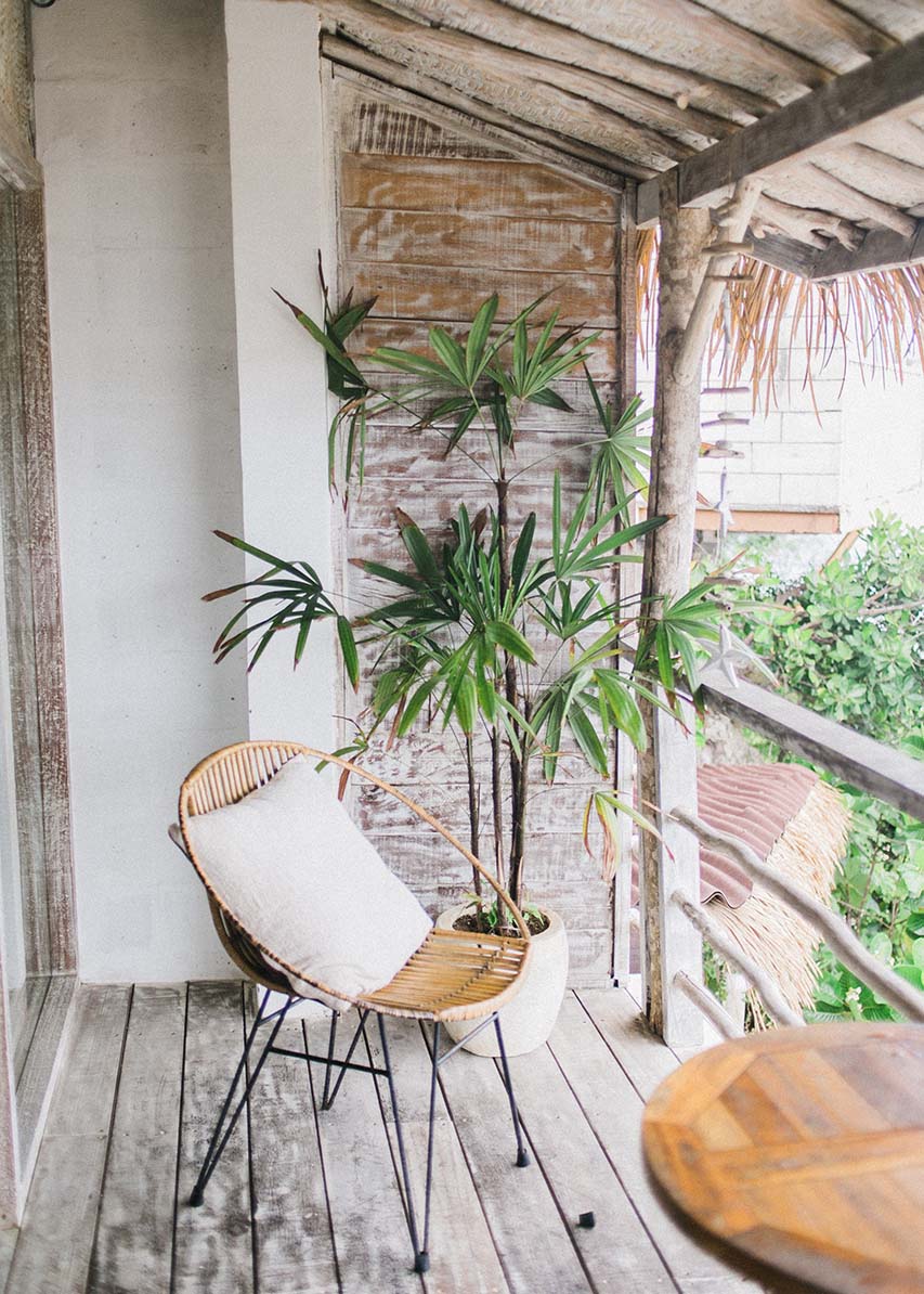 a patio with a wooden floor, a wooden table, a lounge chair and a plant - bringing nature into your home
