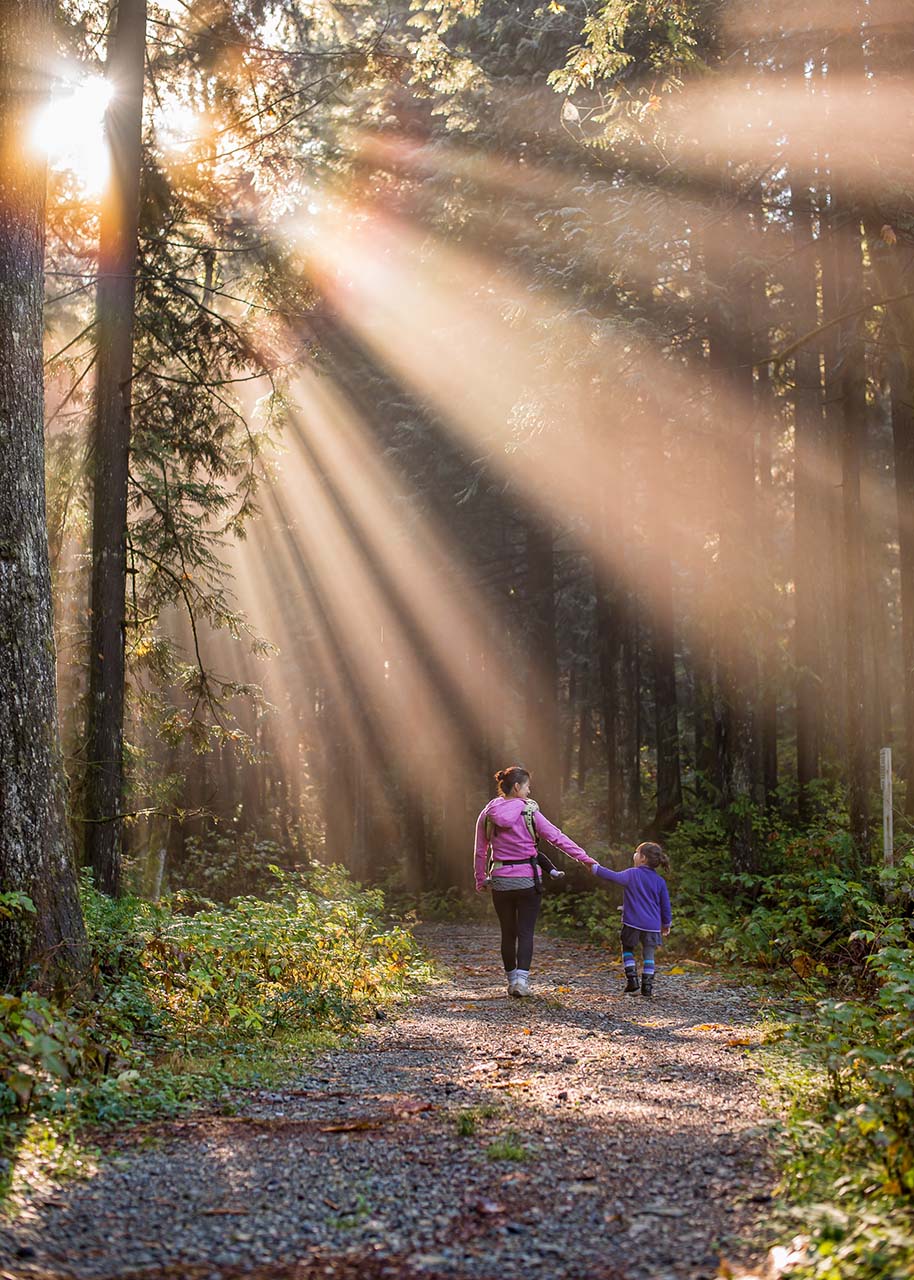 mother and daughter taking a walk in the forest - slow living with kids