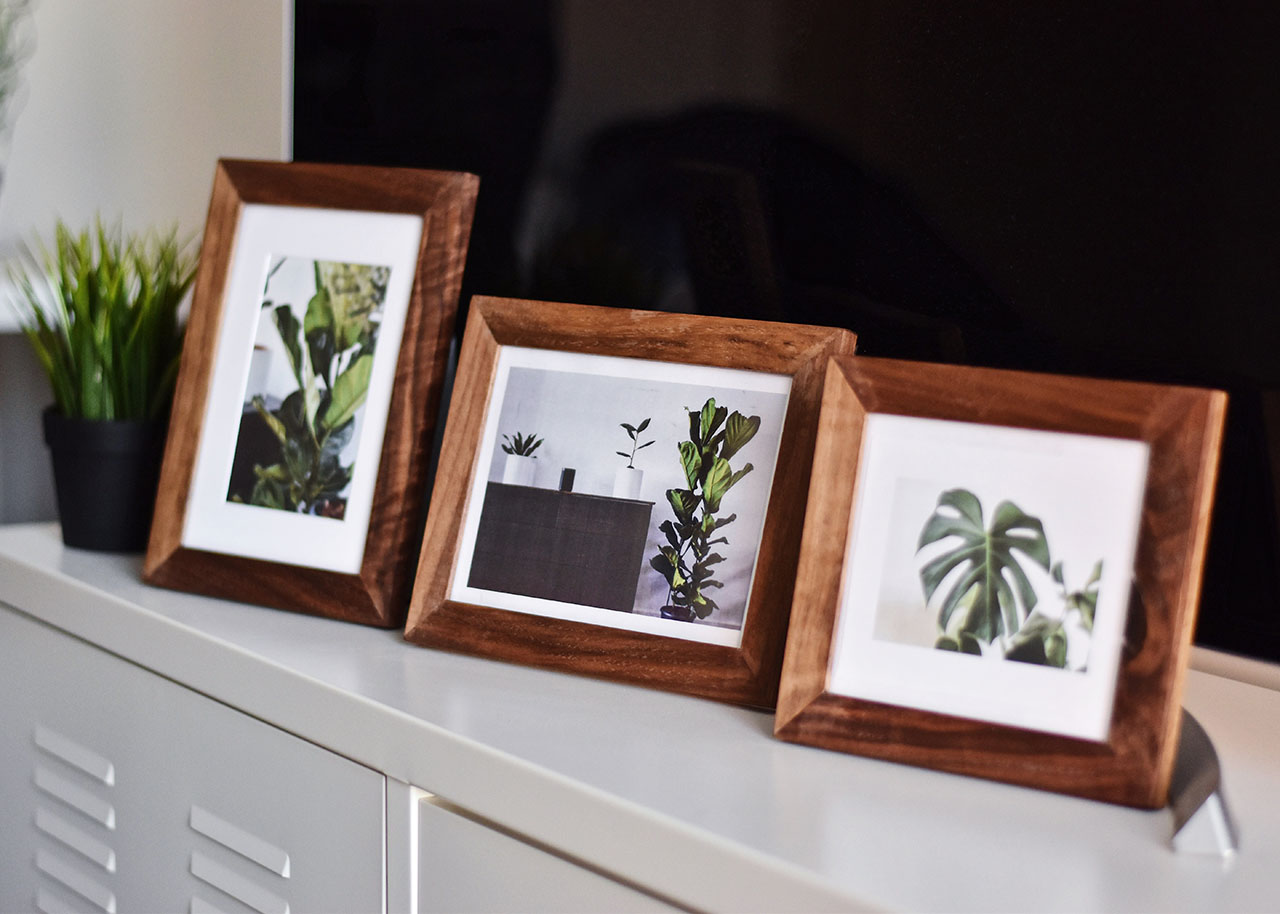 3 wooden photo frames on a white metal cabinet
