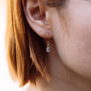 woman wearing moonstone earrings from honeydew club