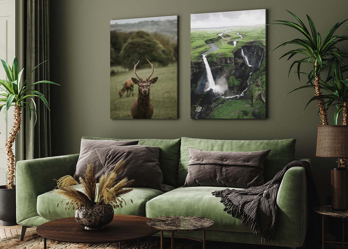 a cosy living room with green colours and two big art prints on the wall 