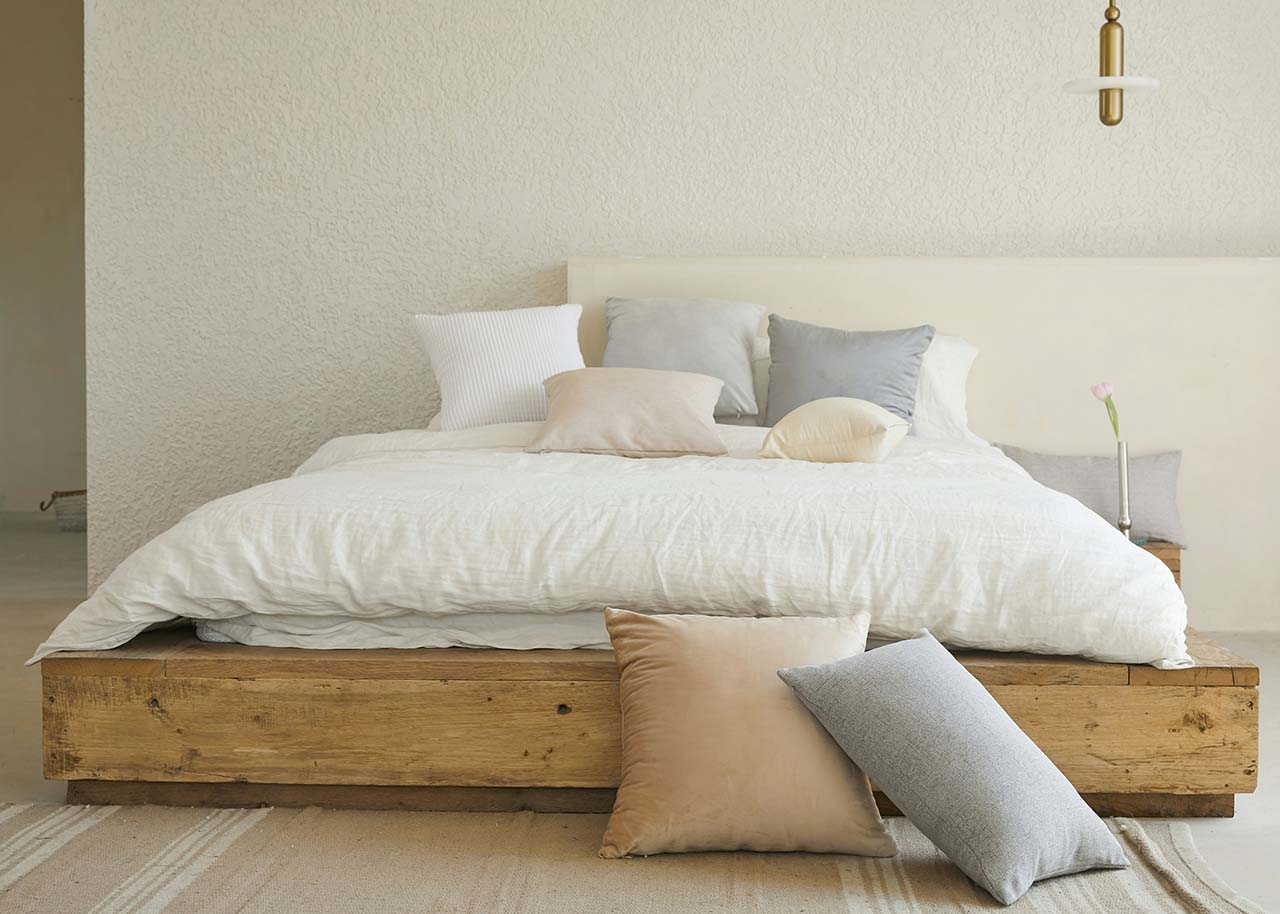 a wooden bed with cushions - sustainable furniture