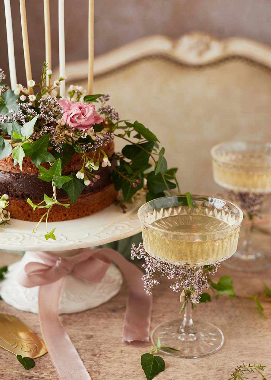 a wedding cake with flowers and a glass of champagne with flowers attached to it - plan a memorable wedding