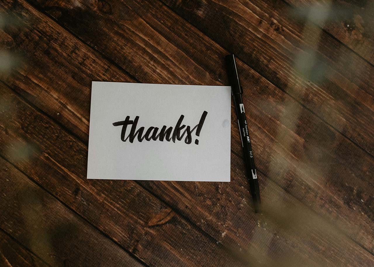 handwritten thank you card with a pen on a table - how to make your small business appear more professional