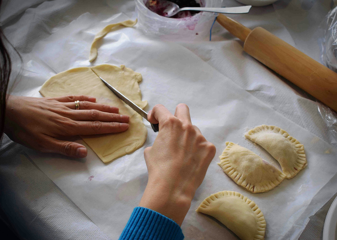 two woman's hands preparing a pasta dish - mindful eating