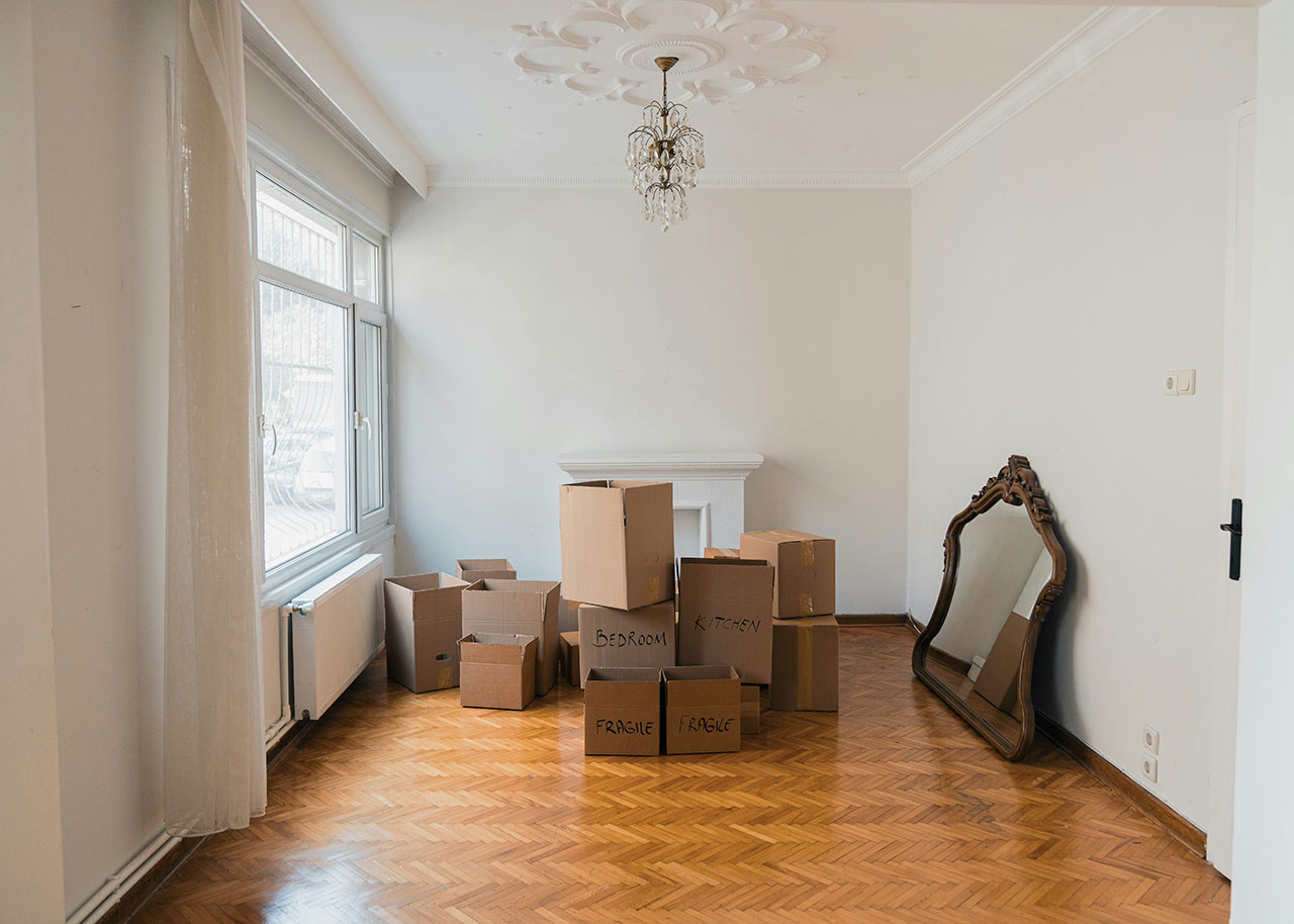 an empty living room with moving boxes - selling your home