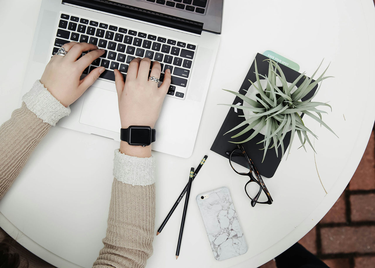 a woman on a bed with a laptop, holding a cup of coffee - next steps to future-proof your small business