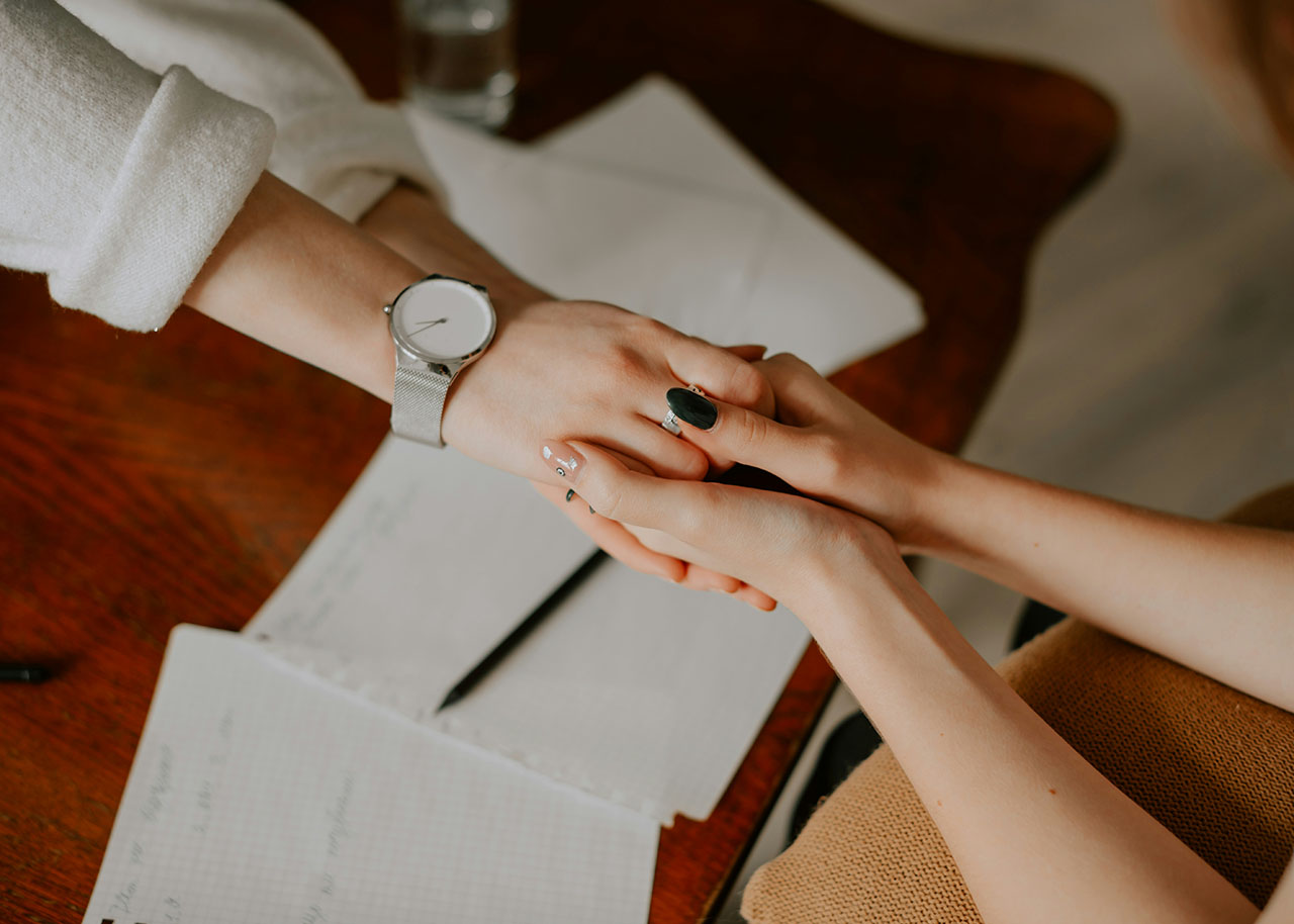 two women holding hands - authentic connections