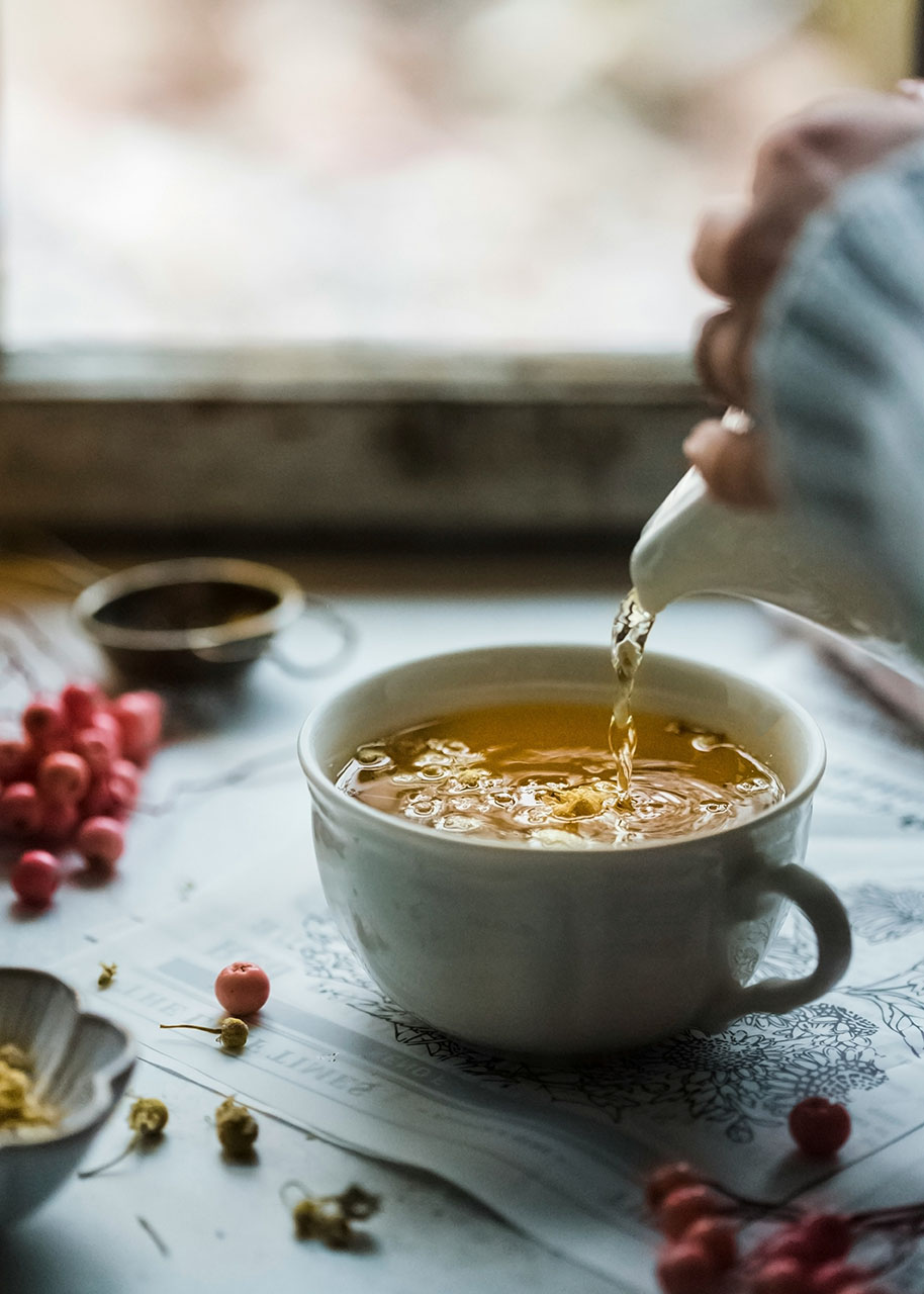 a woman pouring a homemade Herbal Tea